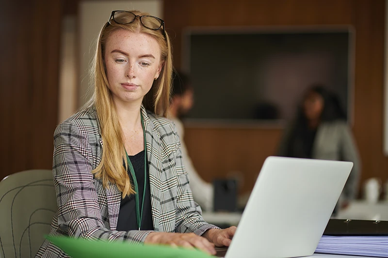 A paralegal typing on a laptop in the office